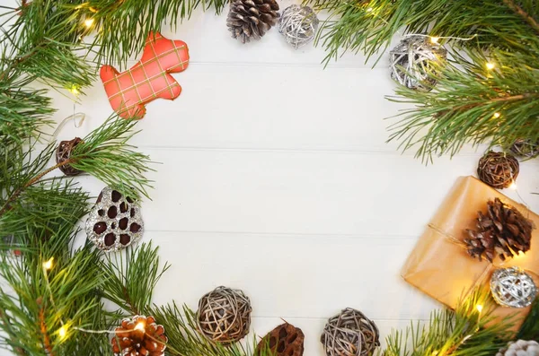 Weihnachtsbaum, getrocknete Orangen, Plätzchen, Walnüsse, Haselnüsse, Tannenzapfen, Kugeln, Zimtstangen auf Holzgrund. — Stockfoto