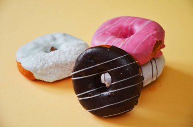 Çikolatalı buzlu, pembe sırlı ve bonibon donuts ile çeşitli çörekler. Çörek karışımı basit arka plan üzerinde