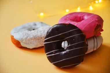 Çikolatalı buzlu, pembe sırlı ve bonibon donuts ile çeşitli çörekler. Çörek karışımı basit arka plan üzerinde