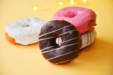 Çikolatalı buzlu, pembe sırlı ve bonibon donuts ile çeşitli çörekler. Çörek karışımı basit arka plan üzerinde