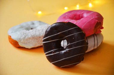 Çikolatalı buzlu, pembe sırlı ve bonibon donuts ile çeşitli çörekler. Çörek karışımı basit arka plan üzerinde