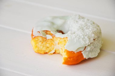 Renkli donut taş masada. Üstten görünüm. Çikolatalı buzlu, pembe sırlı ve bonibon donuts ile çeşitli börekler.