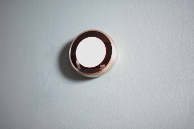 Akıllı ev termostatı mavi duvarda izole edilmiş. Kopya ve yazıya yer var. Yeşil teknoloji ısıtma ve soğutma