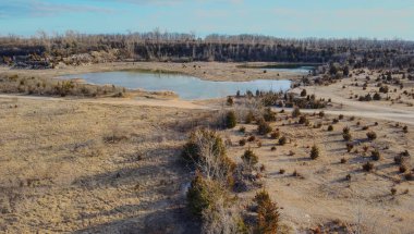 Sunset 'te terk edilmiş bir taş ocağı. Çorak bir uçağın üstünden manzarayı seyret. Göletler ve ölü bitkiler