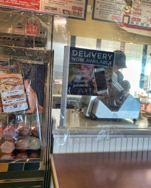 Dayton, OH-2 Nisan 2020: Jersey Mike 's Subs' da çalışanları öksürük ve COVID-19 müşterilerinden korumak için plastik ambalaj koruması.