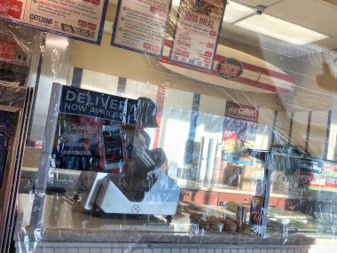Dayton, OH-2 Nisan 2020: Jersey Mike 's Subs' da çalışanları öksürük ve COVID-19 müşterilerinden korumak için plastik ambalaj koruması.