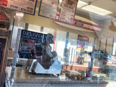 Dayton, OH- April 2, 2020: Plastic wrap safety guard over food at Jersey Mike's Subs to protect employees from coronavirus due to coughs and sneezes from COVID-19 customers clipart