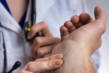 Pratisyen hemşire hastanın nabzını ölçüyor. Hekim, asistan, hemşire ya da eczacı olabilir. Hasta için tıbbi profesyonel bakım