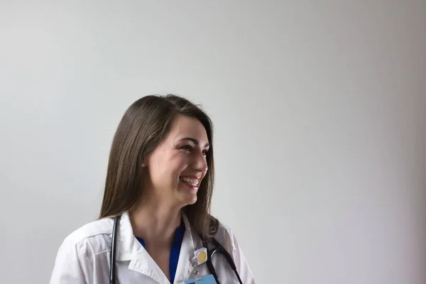 Gri arka planda izole edilmiş, yakından çekilmiş bir sağlık uzmanı. Kadın doktor ya da pratisyen hemşire portresi