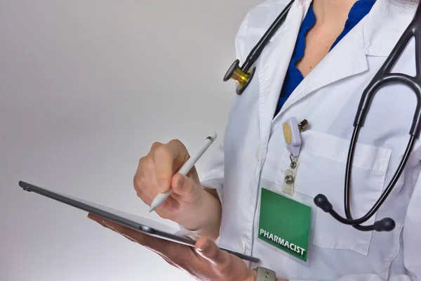 Healthcare worker using tablet to conduct healthcare. doctor or nurse practitioner Writing prescription. Physician assistant wearing stethoscope