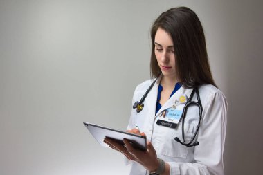 Kadın sağlık çalışanı, hastalarla ilgilenmek için teknolojiyi kullanıyor. Yoğun bakımdaki kadın. Hastayla ilgilenen doktor.