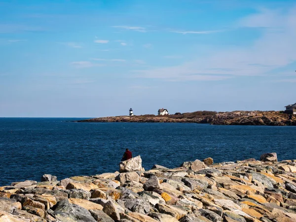 在洛克波特 人们坐在海湾和大海的后面 灯塔在远处 — 图库照片