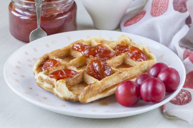 Waffle ile beyaz bir plaka üzerinde bir Erik reçeli
