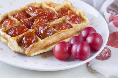 Waffle ile beyaz bir plaka üzerinde bir Erik reçeli