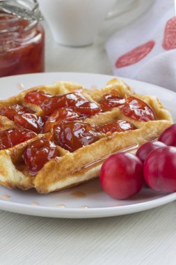 Waffle ile beyaz bir plaka üzerinde bir Erik reçeli