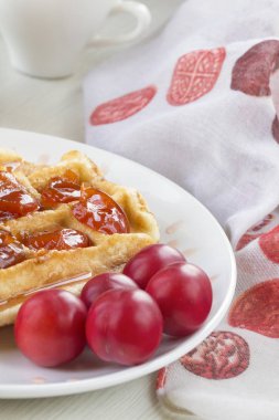 Waffle ile beyaz bir plaka üzerinde bir Erik reçeli