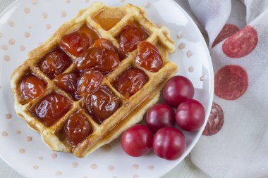 Waffle ile beyaz bir plaka üzerinde bir Erik reçeli