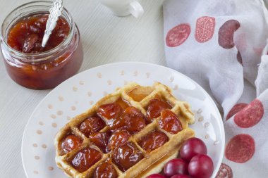 Waffle ile beyaz bir plaka üzerinde bir Erik reçeli