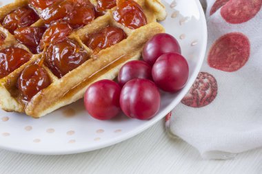 Waffle ile beyaz bir plaka üzerinde bir Erik reçeli