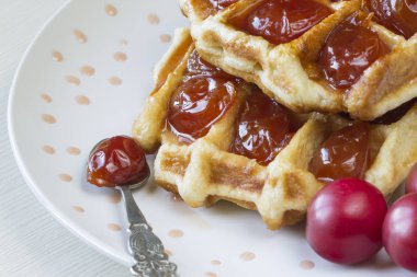 Waffle ile beyaz bir plaka üzerinde bir Erik reçeli