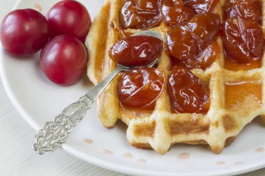 Waffle ile beyaz bir plaka üzerinde bir Erik reçeli