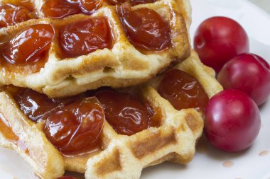 Waffle ile beyaz bir plaka üzerinde bir Erik reçeli