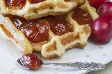 Waffle ile beyaz bir plaka üzerinde bir Erik reçeli