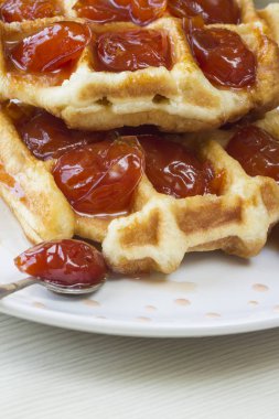 Waffle ile beyaz bir plaka üzerinde bir Erik reçeli