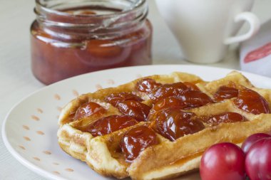 Waffle ile beyaz bir plaka üzerinde bir Erik reçeli