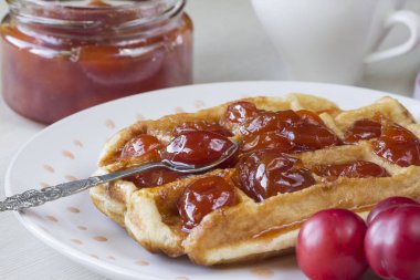 Waffle ile beyaz bir plaka üzerinde bir Erik reçeli