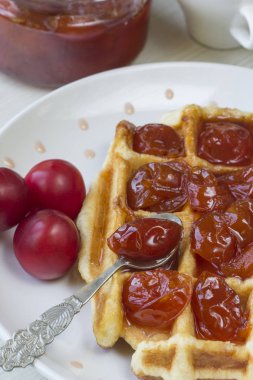 Waffle ile beyaz bir plaka üzerinde bir Erik reçeli