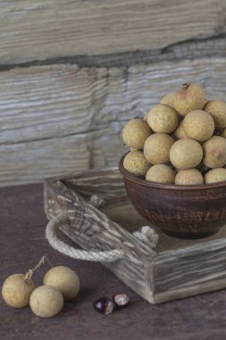 Bir tepsi üzerinde seramik bir kasede Longan 