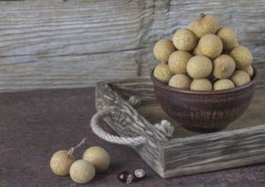 Bir tepsi üzerinde seramik bir kasede Longan 
