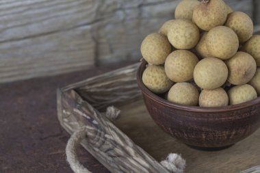 Bir tepsi üzerinde seramik bir kasede Longan 
