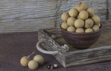 Bir tepsi üzerinde seramik bir kasede Longan 