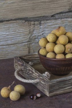 Bir tepsi üzerinde seramik bir kasede Longan 