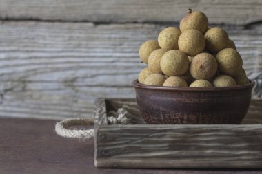Bir tepsi üzerinde seramik bir kasede Longan 