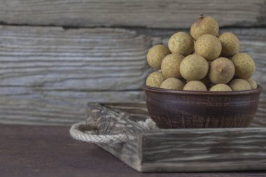 Bir tepsi üzerinde seramik bir kasede Longan 