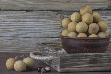 Bir tepsi üzerinde seramik bir kasede Longan 