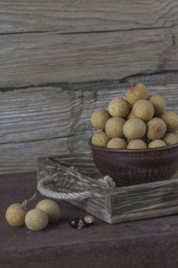 Bir tepsi üzerinde seramik bir kasede Longan 