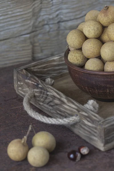 Longan in una ciotola di ceramica su un vassoio — Foto Stock