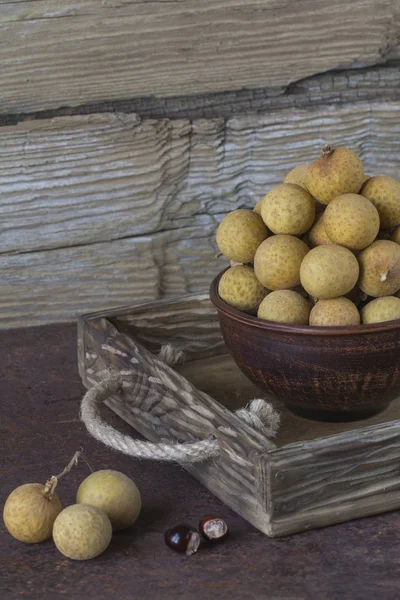 Bir tepsi üzerinde seramik bir kasede Longan 