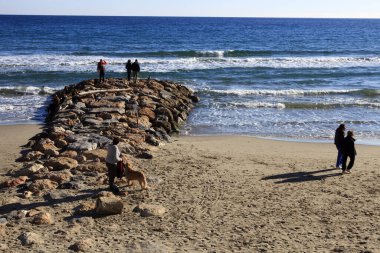 Alassio (SV), Italy - February 15, 2017: Tourist relaxing at Alassio beach, Riviera dei Fiori, Savona, Liguria, Italy.