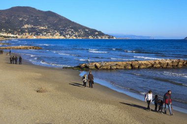 Alassio (SV), Italy - February 15, 2017: Tourist relaxing at Alassio beach, Riviera dei Fiori, Savona, Liguria, Italy.