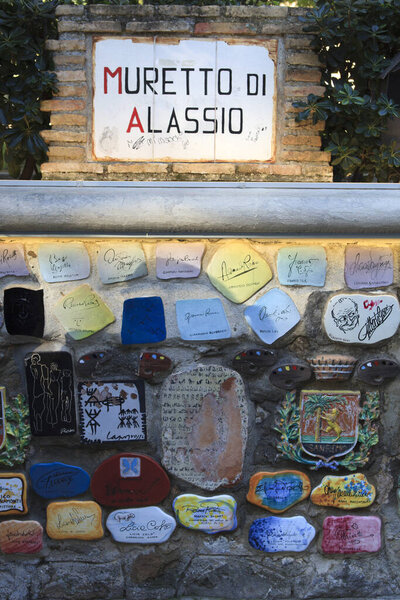 Alassio (SV), Italy - February 15, 2017: Ceramic icons with celebrities signature at the famous "Muretto" in Alassio town, Riviera dei Fiori, Savona, Liguria, Italy.