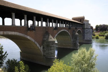 Pavia (PV), Italy - June 09, 2018: The Ponte Coperto (covered bridge), also known as the Ponte Vecchio (old bridge), a brick and stone arch bridge over the Ticino River in Pavia, Lombardy, Italy