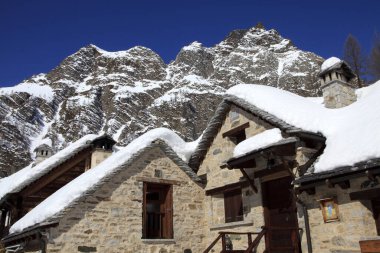 Devero Park ( Verbano-Cusio-Ossola ), Italy - January 15, 2017: Crampiolo village and houses in Alpe Devero Park, Ossola Valley, VCO, Piedmont, Italy