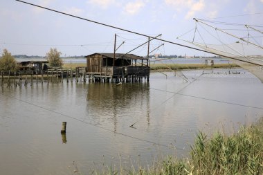 Po Nehri (Fe), İtalya - 30 Nisan 2017: Po Nehri üzerinde ağı olan eski bir balıkçı evi, Delta Bölgesel Parkı, Emilia Romagna, İtalya