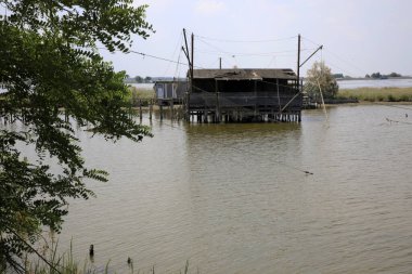 Po Nehri (Fe), İtalya - 30 Nisan 2017: Po Nehri üzerinde ağları olan eski bir balıkçı evi, Delta Bölgesel Parkı, Emilia Romagna, İtalya