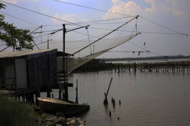 Po Nehri (Fe), İtalya - 30 Nisan 2017: Po Nehri üzerinde ağları olan eski bir balıkçı evi, Delta Bölgesel Parkı, Emilia Romagna, İtalya